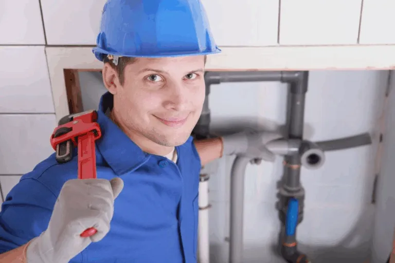 A man in blue shirt and hat holding a wrench