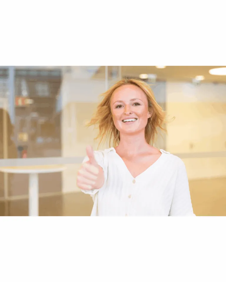 Smiling woman giving a thumbs up gesture showing satisfaction and confidence